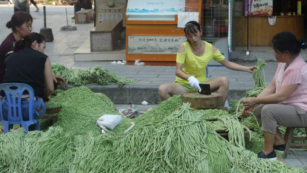 Women preparing green beans for Luosifen 